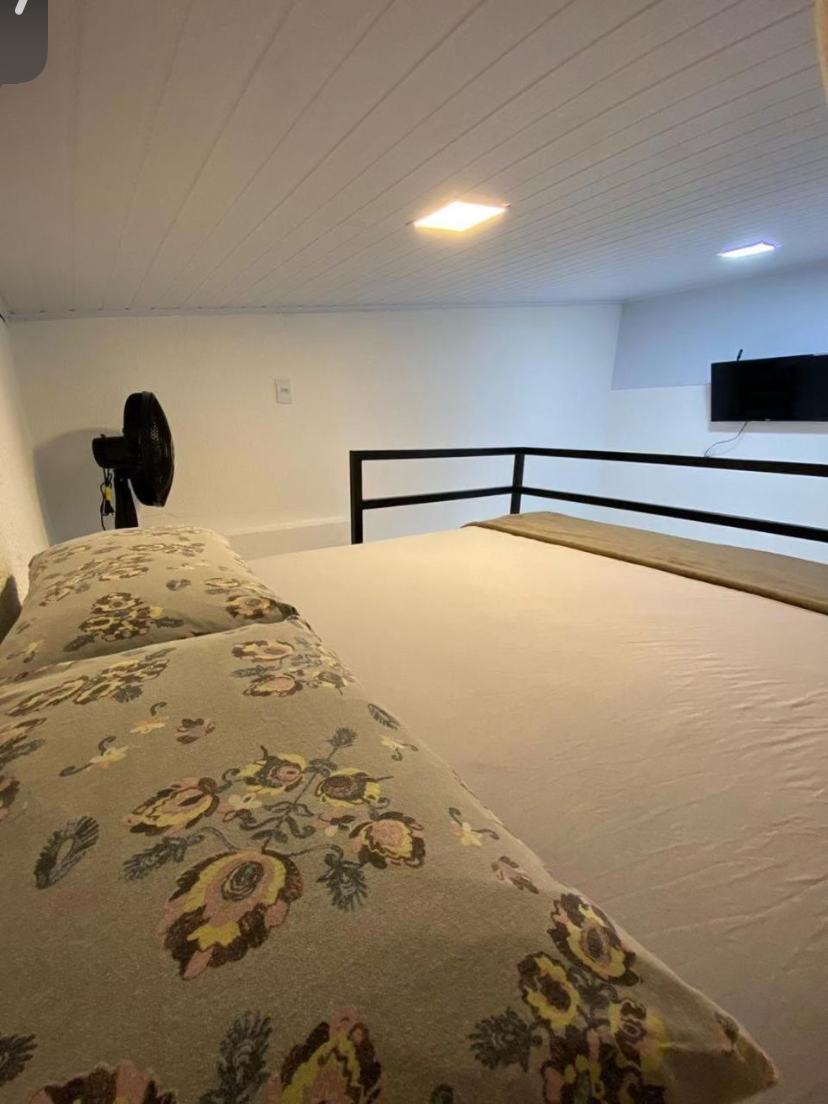 Mezanino com cama de casal e televisão